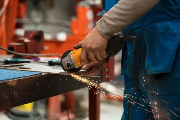 Worker working with a circular grinder on a metal with sparks Technician worker cutting metal with many sharp sparks. Using equipments to cat iron